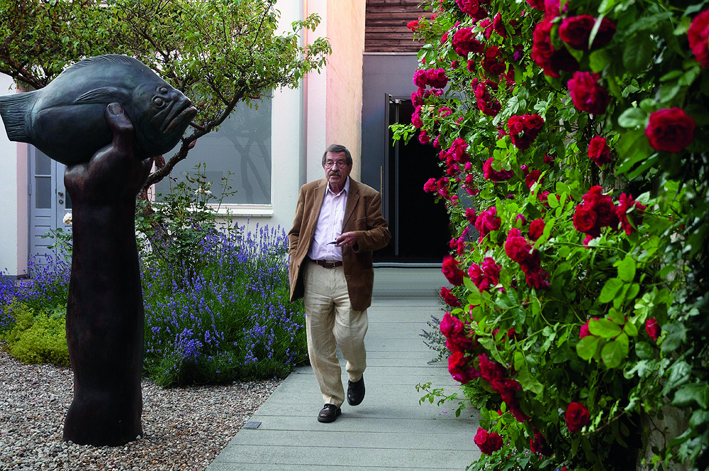 Günter Grass läuft durch den Garten seines Hauses.