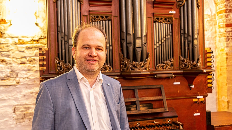 Der Marienorganist steht vor einer spätbarocken Orgel.