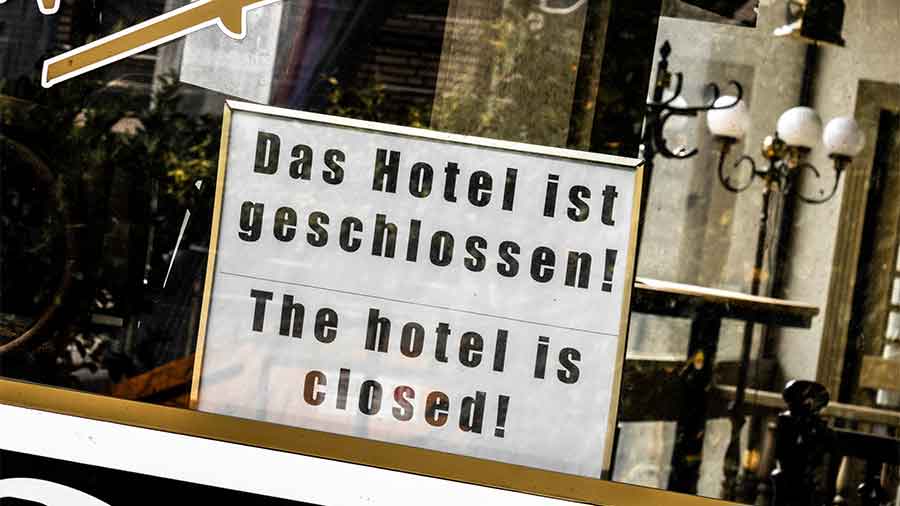 Auf einem Schild in einem Fenster steht "Das Hotel ist geschlossen" / "The hotel is closed"