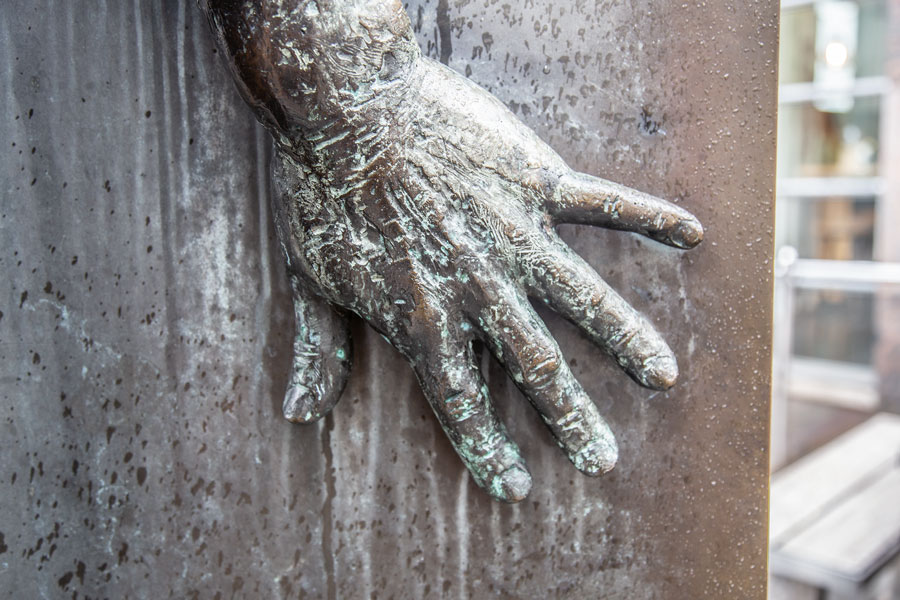 Die Hand eines Bronze Mannes in der Plastik.
