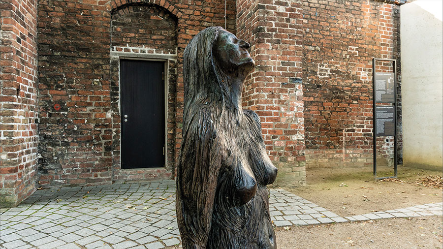 Die Skulptur stellt eine weibliche nackte Frau da.