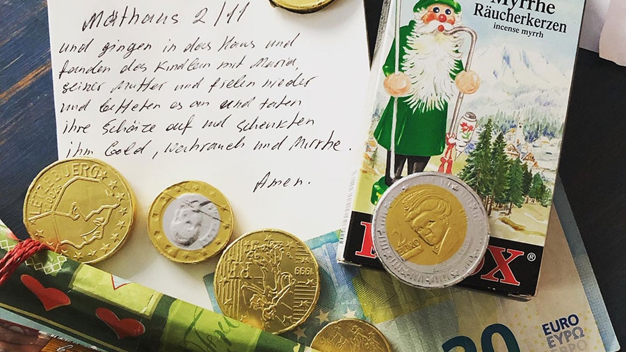 Mehrere Schokladen-Münzen, ein 20-Euro-Schein, ein handgeschriebener Zettel mit der Weihnachtsgeschichte, Marzipan und Räucherkerzen liegen nebeneinander