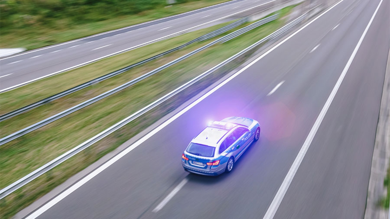 Ein Polizeiauto rast auf der Autobahn.