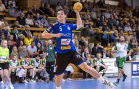 Ein Handballer vom VfL Lübeck-Schwartau springt und wirft dabei den ball in einer Handballhalle.