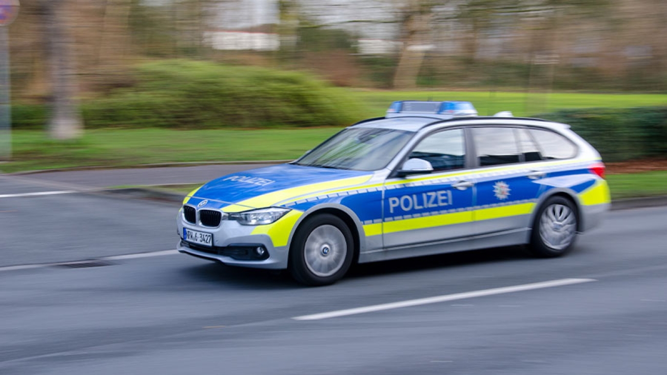 Ein Polizeiwagen fährt auf einer Straße.