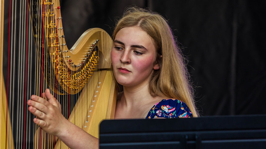 Eine blonde junge Frau spielt Harve.