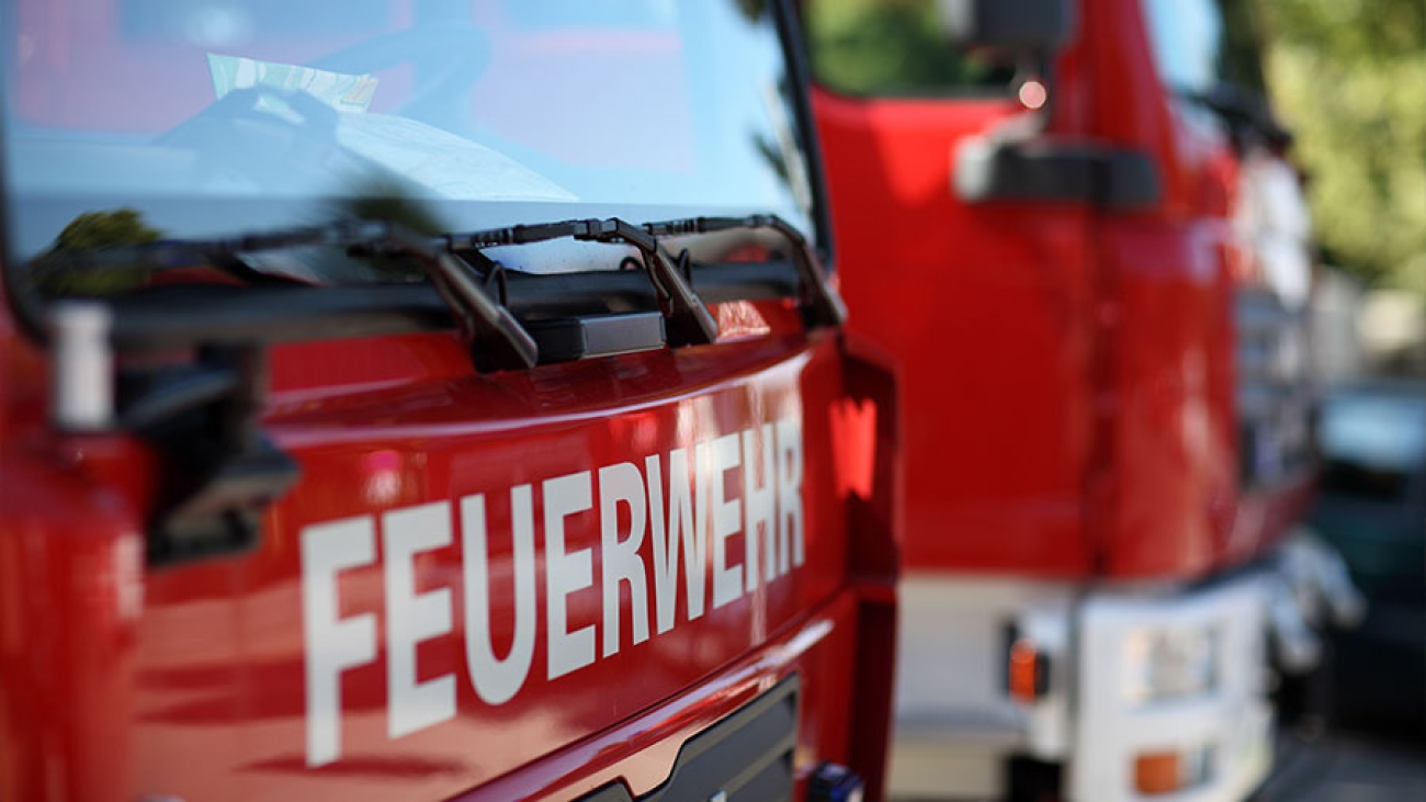 Zwei Feuerwehrautos stehen neben einander und sind aus nächster Nähe schräg fotografiert.