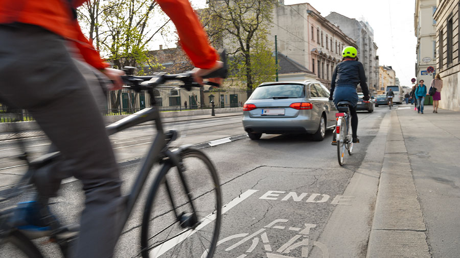 Zwei Fahrradfahrer im Straßenverkehr.