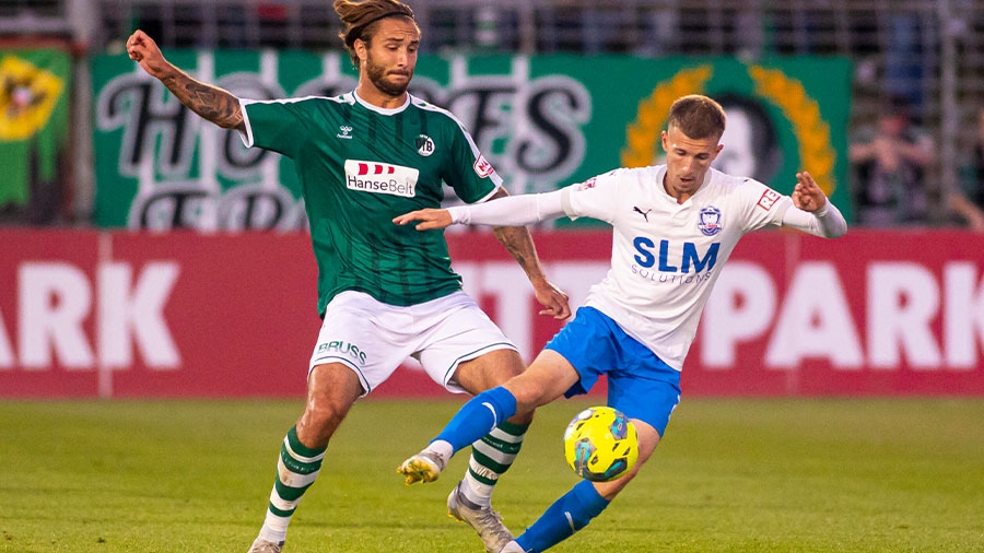 Zwei Fußballer aus Lübeck vom FC Phönix und vom VfB kämpfen um den Ball.