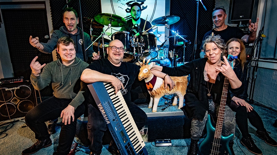 Die RockFock Band posiert gemeinsam mit Zieglinde und ihren Instrumenten vor der Kamera.
