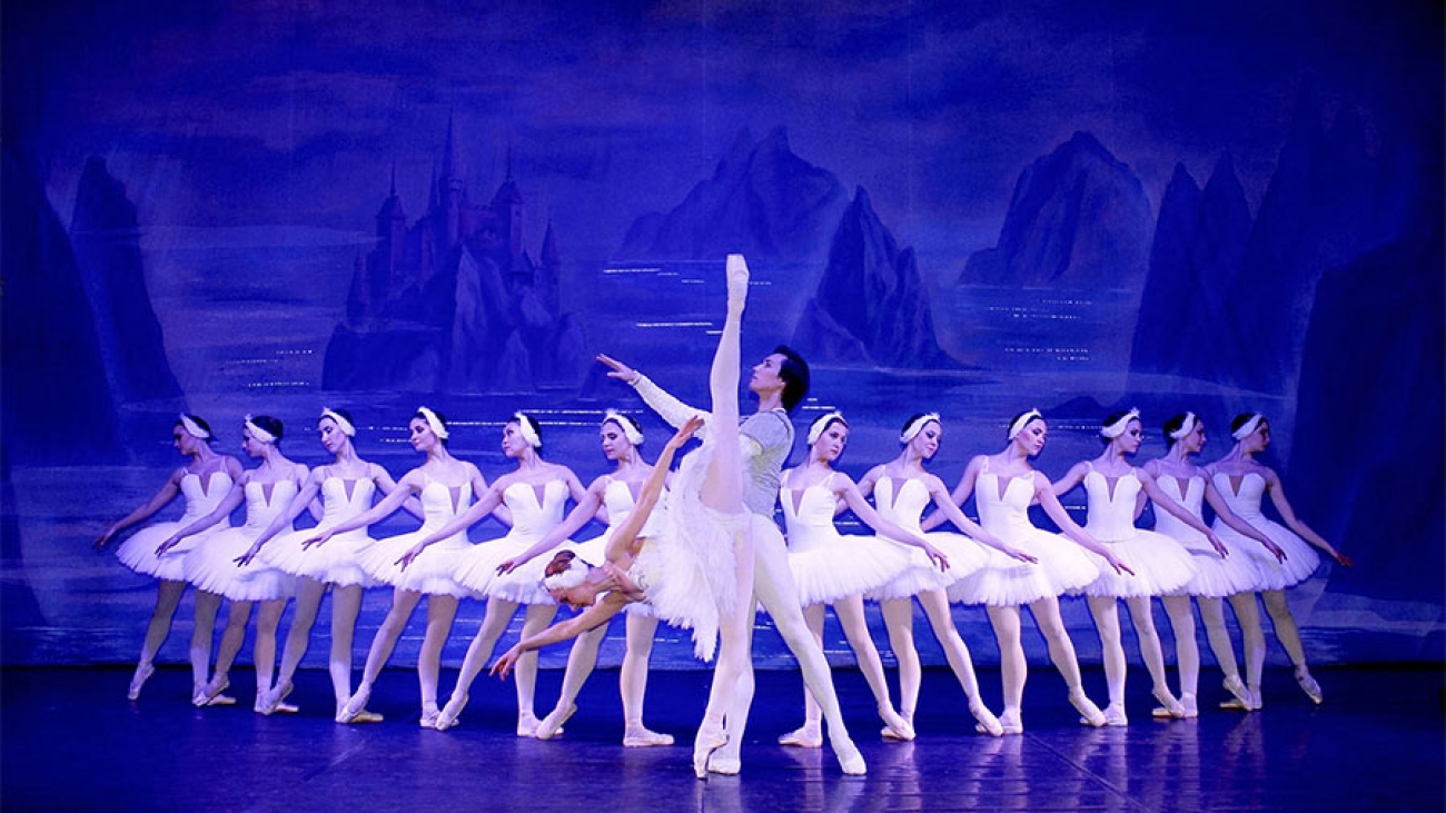 Balletttänzerinnen und ein Tänzer tanzen das berühmte Stück Schwanensee.