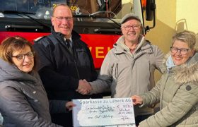 Ein Scheck in der Höhe von 750 Euro wird an die Freiwillige Feuerwehr Lübeck überreicht.