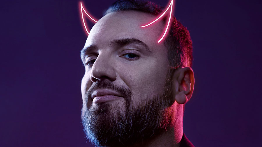 Ein Mann posiert in blauem und rotem Licht und hat Teufelshörner.