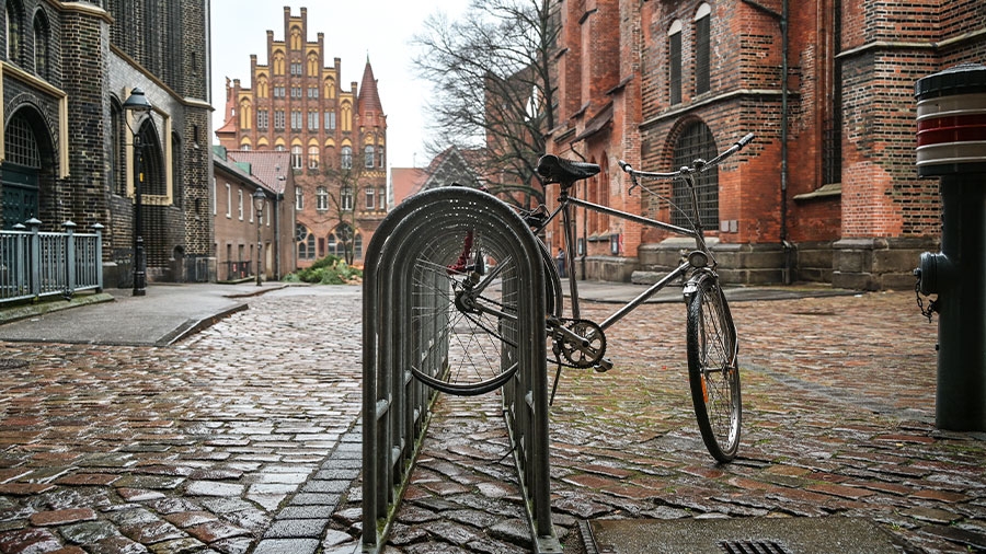 Ein Fahrrad steht an einem Fahrradständer neben der St. Marien Kirche auf der Altstadtinsel Lübecks.