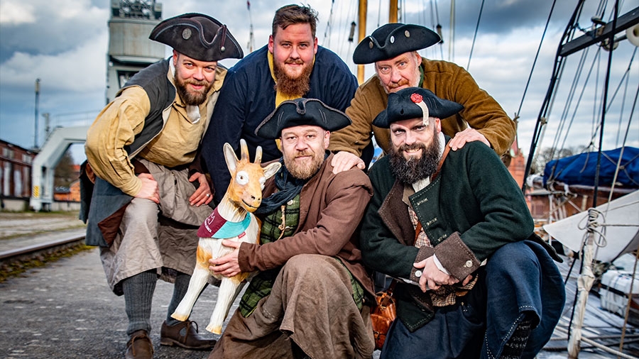 5 Piraten stehen gemeinsam mit der Ziege im Lübecker Hafen.