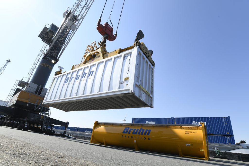 Ein Kran hebt einen riesigen Container hoch.