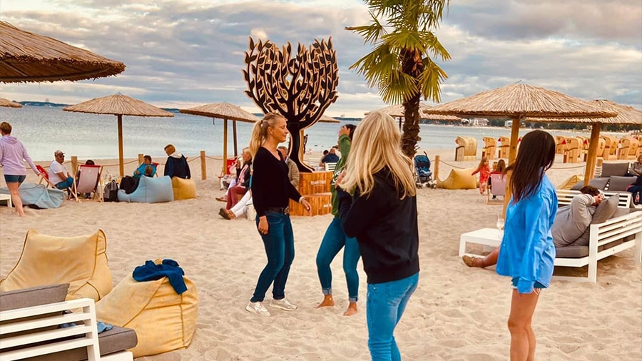 Tanzende Menschen an einer Strandbar.
