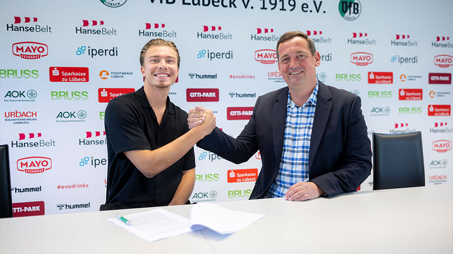 Der neue Torwart und der Vorstand des VfB machen einen Handschlag vor der Kamera.