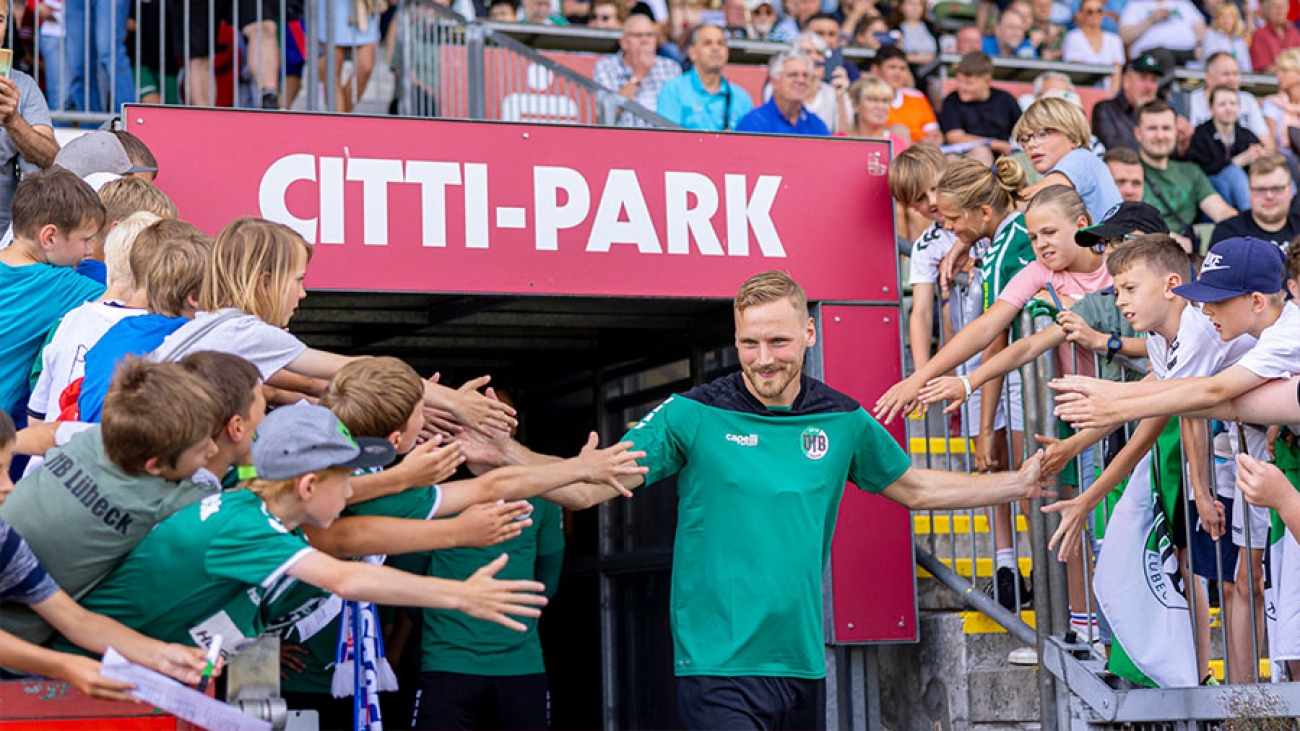 Ein VfB Spieler läuft ins Stadion ein.