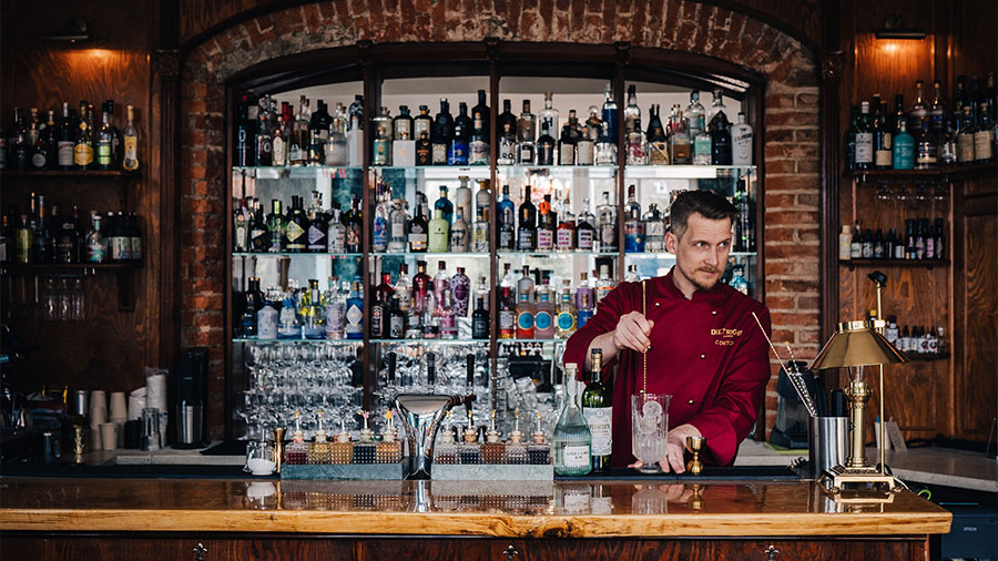 Ein Barkeeper mischt einen Drink an einer Bar.