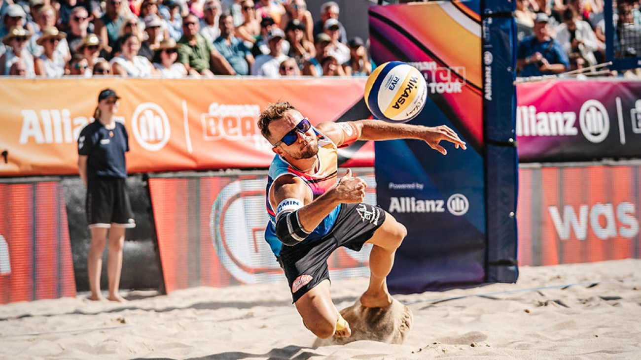 Ein Mann spielt Beach-Volleyball.