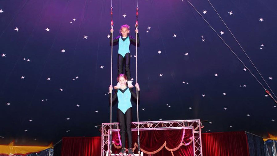 2 Kinder machen Kunststücke im Zirkus.