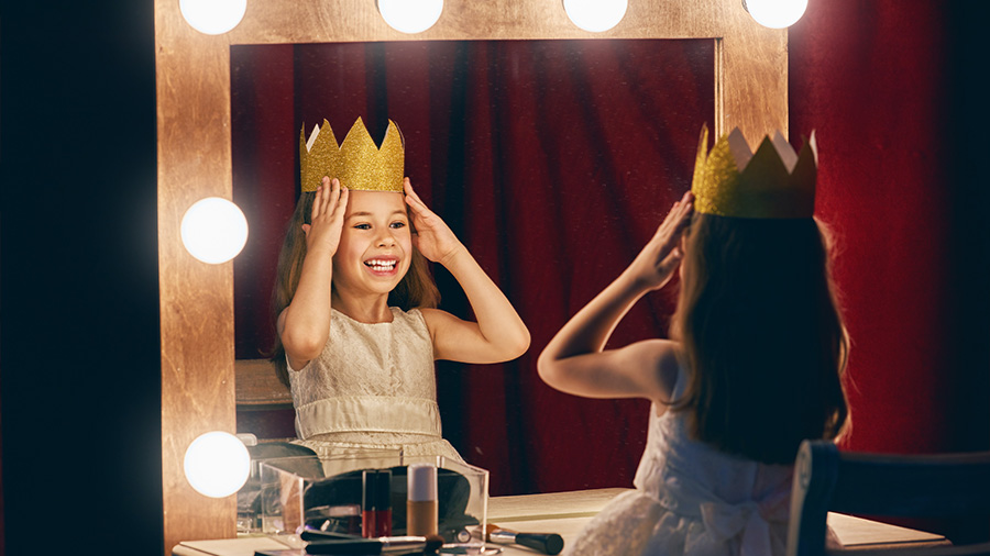Ein Kind vor einem Spiegel mit einer Krone