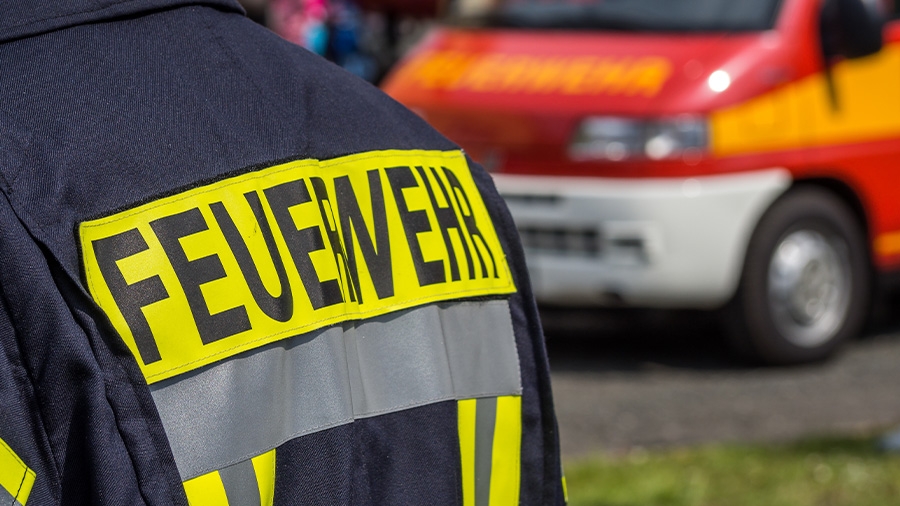 Feuerwehrmann mit Auto im Hintergrund