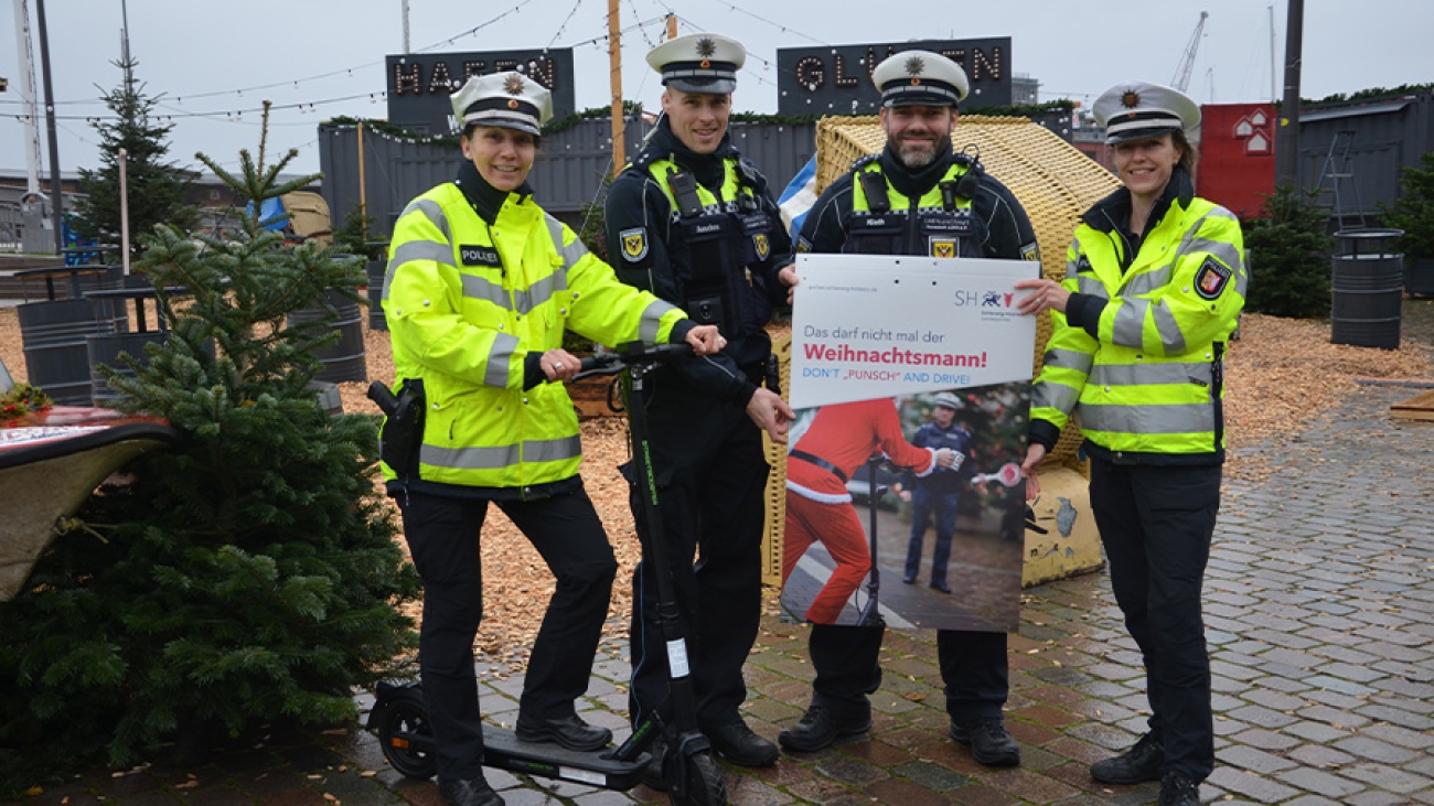 Polizisten halten ein Plakat hoch. C. Polizei Lübeck