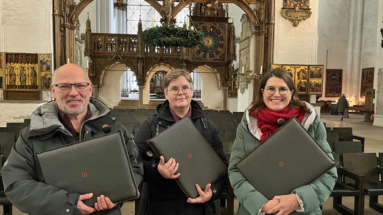 Pastor Martin Klatt, Kerstin Oetling von der Domwache und Pastorin Margrit Wegner zeigen die neuen Sitzkissen, die im Dom schon sehr gut ankommen. (Foto: Annkathrin Bornholdt)