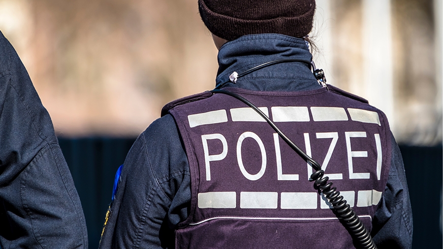 Mitarbeiterin der Polizei von hinten fotografiert