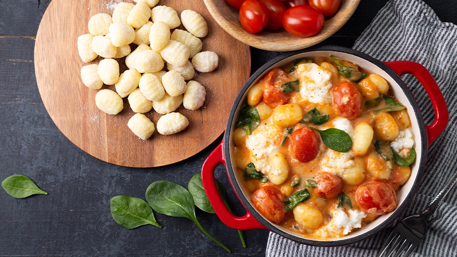 Gnochi mit Tomaten auf einem Teller angrichtet