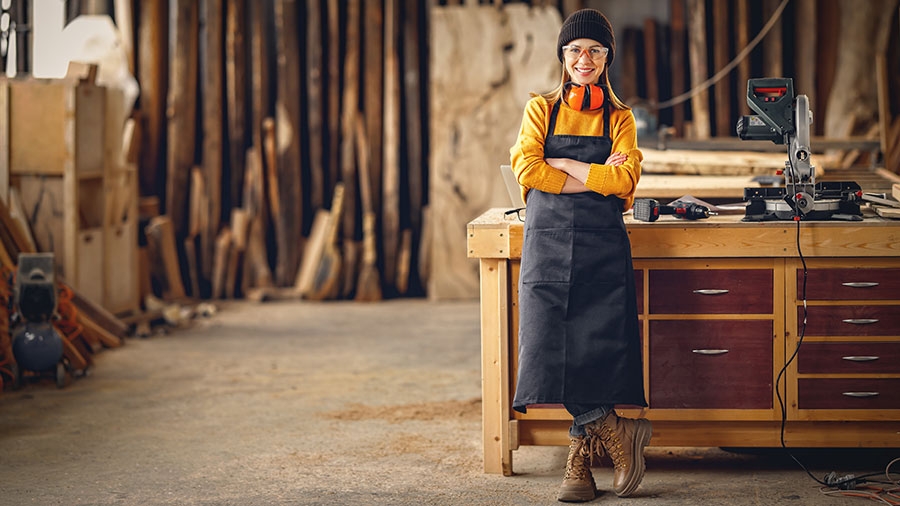 Frau aus dem Handwerk steht vor eine Arbeitsbank