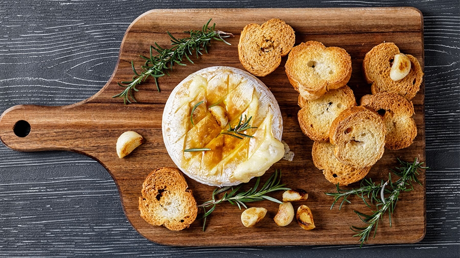 Ofenkäse angerichtet auf einem Brett