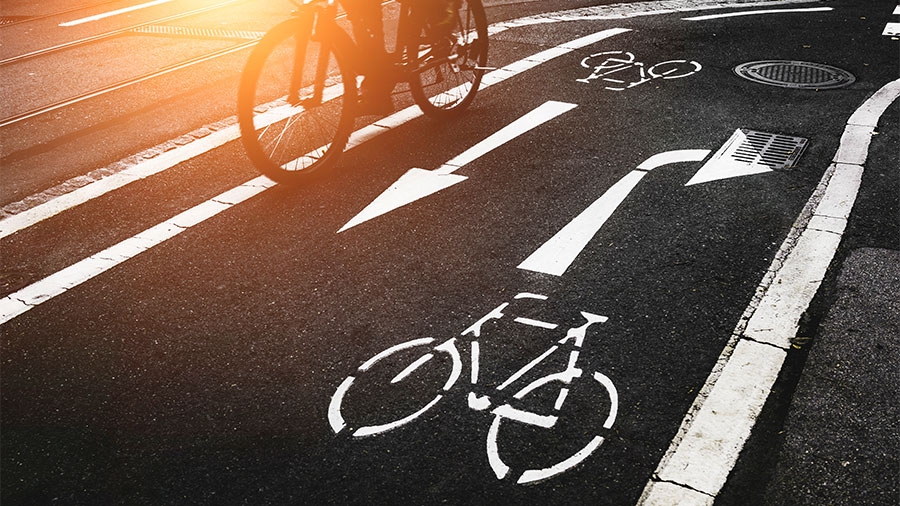 Radweg im Sonnenaufgang mit einem Radfahrer darauf