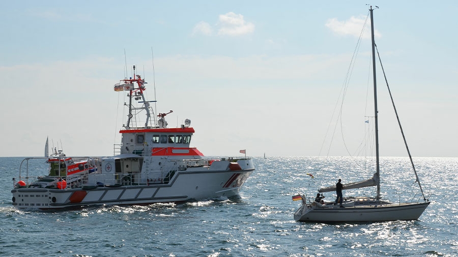 Seenotretter auf dem Meer neben einer Segeljacht