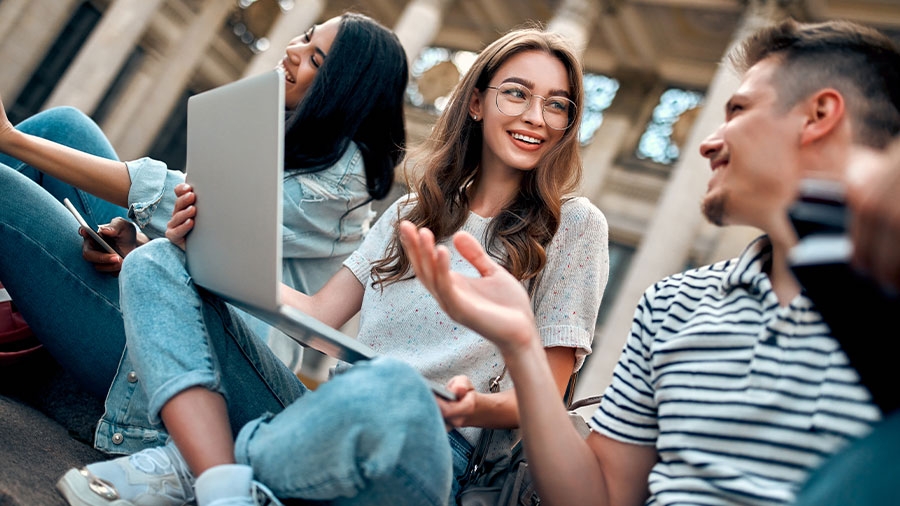 Studenten, die draußen sitzen und diskutieren